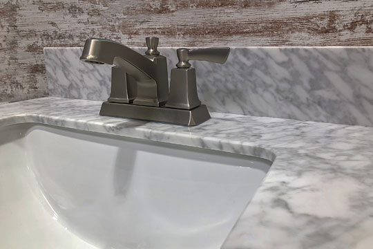 marble countertop with bathroom faucet and vanity sink